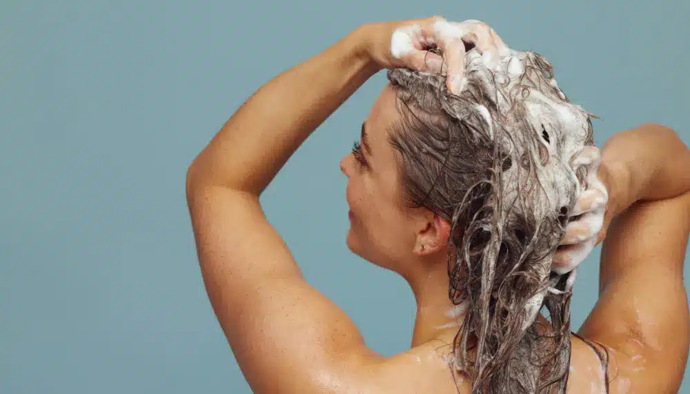 Femme pendant sa routine capilaire avec de l'huile de cade