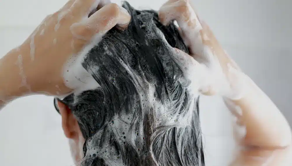 Femme se faisant un shampoing à l'huile de cade